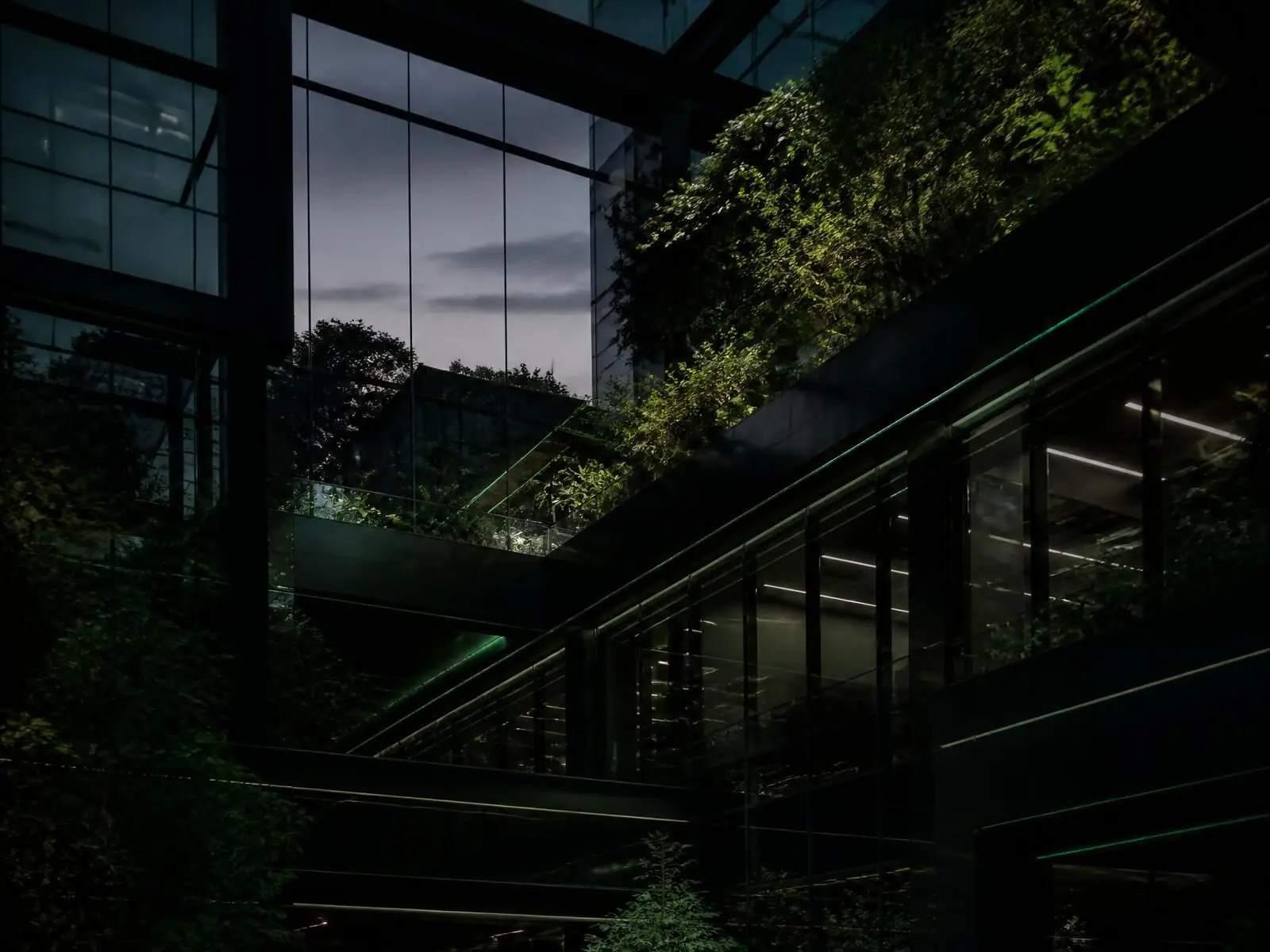 Contemporary green-lit office architecture with integrated foliage
